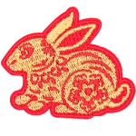 A gold rabbit with a red outline and floral details on its body.