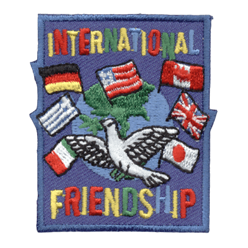 World flags surround a dove in front of the globe. The words International Friendship are above and below.