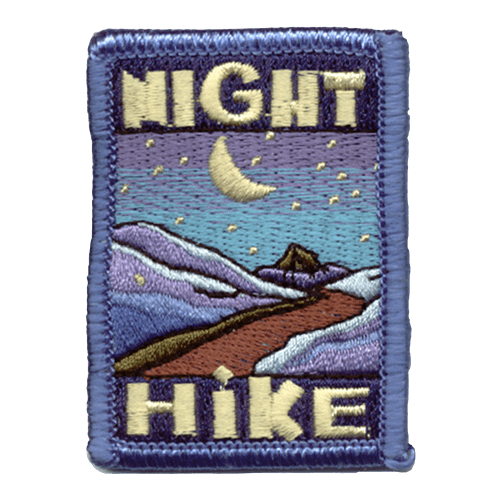 The words Night Hike frame the top and bottom of this patch. In the middle is a mountain trail underneath a starry night sky. 