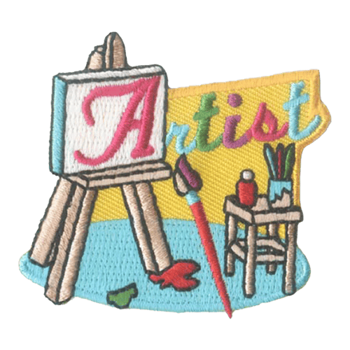 A red A is pained on a white canvas on an eisle. The A is part of the word Artist, which is stitched above a table holding a paintbrush jar.