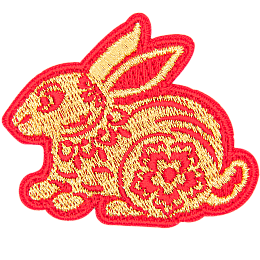 A gold rabbit with a red outline and floral details on its body.