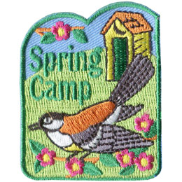 A robin perches on a branch with a cabin in the background, showcasing a traditional spring camp.