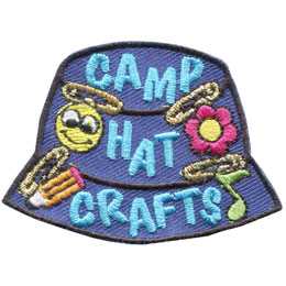 A blue camp hat has little crafts pinned to it. The text Camp Hat Crafts is embroidered on the side.