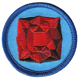 A red garnet is in the centre of a circular blue badge.