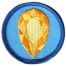 A golden citrine is in the centre of a circular blue badge.