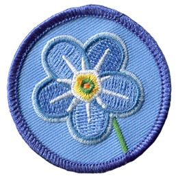 This round, merrow border crest displays a blue forget me not flower with a white starburst in the reaching out from the center.