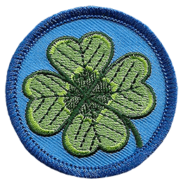 This circular patch displays a four-leaf shamrock on a background of blue.