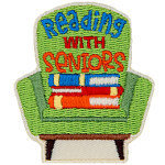A green chair with a stack of books on it. The text reads Reading With Seniors. 