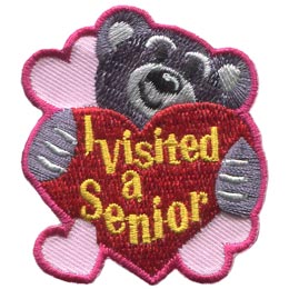 A teddy bear hugs a heart that says I Visited A Senior.