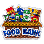 A cardboard box with cans of food inside and the words Food Bank on the side.
