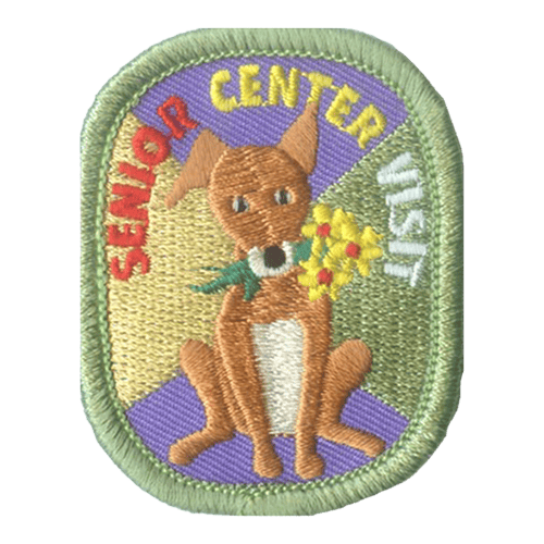 A brown dog holding a bouquet of yellow flowers. Senior Center Visit is stitched in a semi-circle around its head.