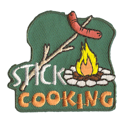 A hotdog on a stick is held over a campfire. The words Stick Cooking overlap with the bottom of the stick.