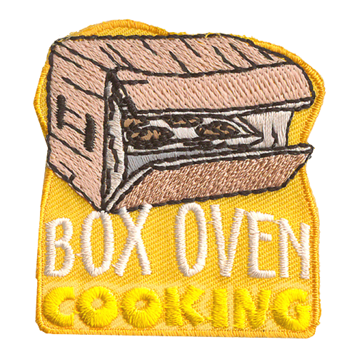 A box with tinfoil and food inside. The text below it reads Box Oven Cooking.