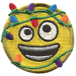 This round, yellow emoji face has two different sized eyes (one looking up and the other looking down) and a wide open, smiling mouth. Multi-coloured Christmas lights are tangled around this emoji.