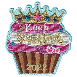 Cupcake with a golden crown and three layers of icing with the words Keep Sparkling On 2022.