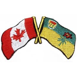 The Canadian flag and Saskatchewan flag cross flag poles, flags open away from each other.