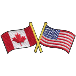This badge displays the Canadian flag on the left and the United States flag on the right. The flag poles of each flag are crossed with each other.