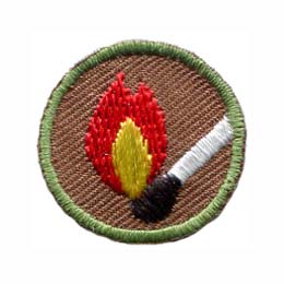 This round one inch badge depicts a lit match.
