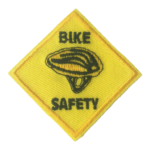 A yellow diamond with a black bike helmet. The words Bike Safety are stitched above and below the helmet.