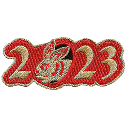 Golden numbers form 2023 on a background of red twill. A golden rabbit is shown peeking out of the 0.