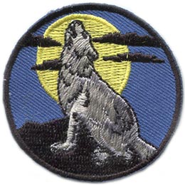 A lone wolf howls at a full moon in this circular patch.