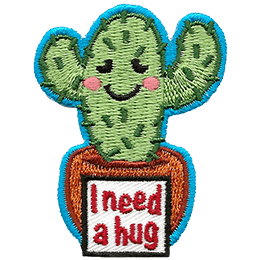 A two-armed cactus has a embarrassed smile as the sign in front of its pot reads I need a hug.