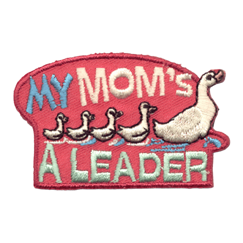 A mother duck leads four little ducklings through a pond. The words ''My Mom's'' rests above the row of ducks and ''A Leader'' sits below.