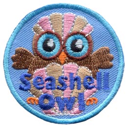 An owl sits behind a beautiful clamshell with its wings outstretched to either side. The owl wears another clam shell like a hat.