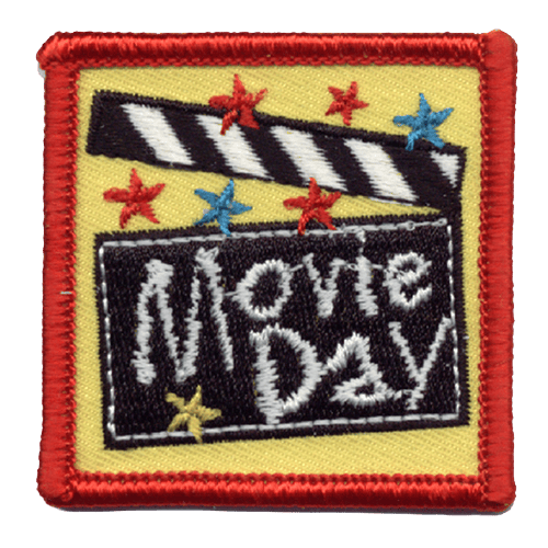 A clapperboard with the words Movie Day stitched across it. It is surrounded by red, blue and yellow stars.