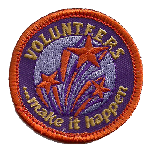 Three shooting stars in red and purple are surrounded by Volunteers ...make it happen stitched around the edge of this circular patch.