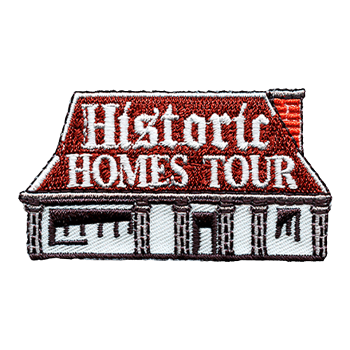 A rectangular house with a red roof and white siding. The words ''Historic Homes Tour'' are on the roof.
