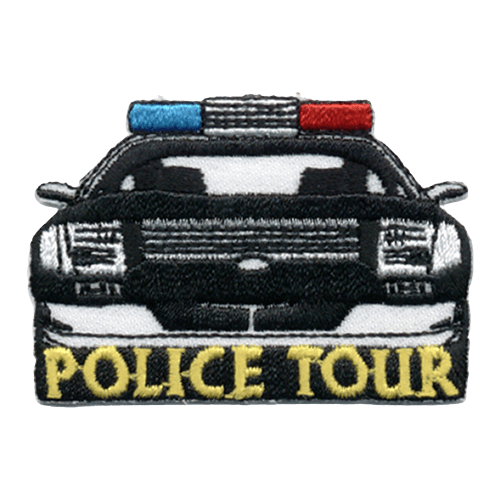 A black and white police car drives towards the viewer with the words ''Police Tour'' embroidered in gold underneath.