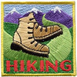 Two hiking boots on a trail that leads into the mountains. The word Hiking is stitched below.